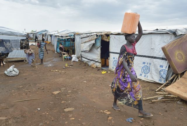 A woman carries water on her head inside a United Nations base in Juba, South Sudan, where some 34,000 people have sought protection since violence broke out in December 2013. More than 112,000 people currently live on UN bases in the war-torn country, most of them afraid of tribally targeted violence.